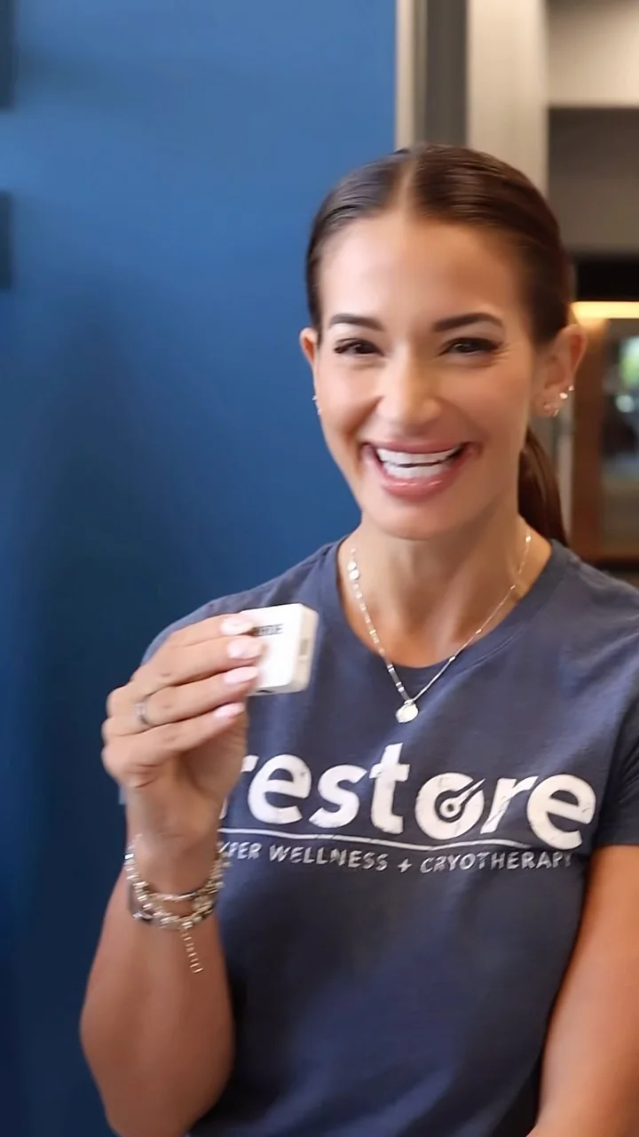 The studio nurse holding a cup, wearing a Restore shirt.